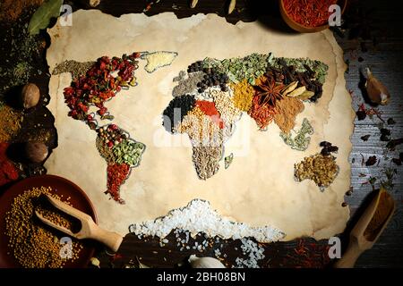 Mappa del mondo fatta da diversi tipi di spezie su sfondo di legno Foto Stock