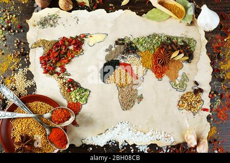 Mappa del mondo fatta da diversi tipi di spezie su sfondo di legno Foto Stock