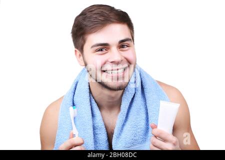 Ritratto di giovane uomo con spazzolino e dentifricio in mano isolato su bianco Foto Stock