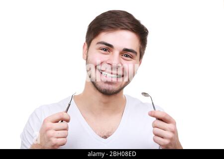 Uomo con attrezzi dentali isolati su bianco Foto Stock