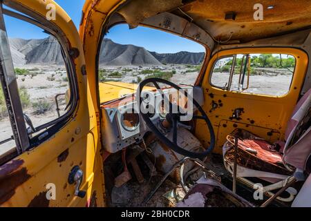 Il sedile di guida di una betoniera arrugginita gialla abbandonata camion in cava di ghiaia Foto Stock