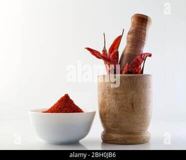 peperoncino rosso con polvere di peperoncino rosso su fondo bianco Foto Stock