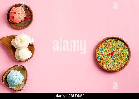 Palle di gelato naturale fresco e freddo fatto in casa o gelato nelle conchiglie biologiche boscose su un colore rosa pastello e decorazione dolce con c. Foto Stock