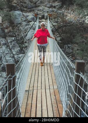 Donna adulta in piedi su un ponte sospeso in legno nella natura. Escursionista femminile a Goynuk Kanyonu in Antalya, Turchia. Foto Stock