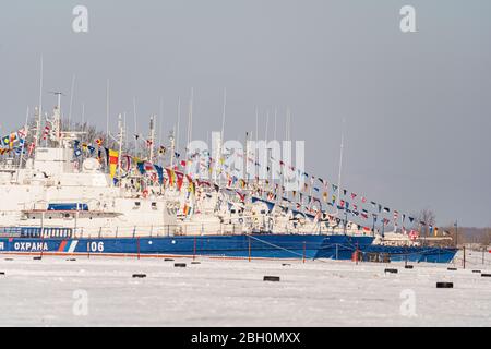 Khabarovsk, Russia 22 febbraio 2020: Le navi militari di confine decorate per una parata sono ormeggiate in una baia ghiacciata del fiume Amur Foto Stock