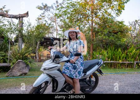 Bella ragazza tailandese su moto. Donna tailandese che indossa il cappello Foto Stock