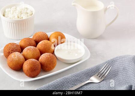 La colazione era ottima. Palline di ciambelle di formaggio cottage su uno sfondo chiaro. Foto Stock