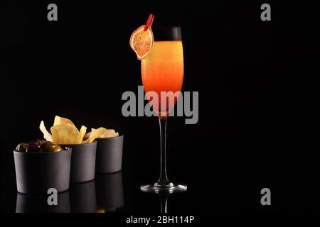 Bellissimo cocktail isolato su sfondo nero con ghiaccio secco fumo. Vapore bianco in fresco vetro freddo, con antipasti e spazio per testi. Ideale per Foto Stock