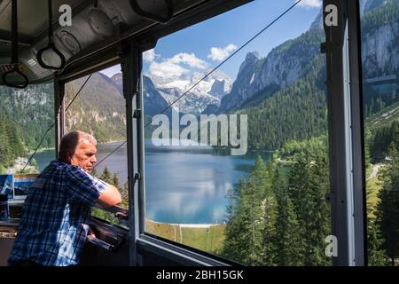 GOSAU, AUSTRIA - 4 2019 LUGLIO: Funivia Gosaukammbahn sopra il lago Vorderer Gosausee sotto Donnerkogel Mountain il 4 luglio 2019 a Gosau, Austria. Foto Stock