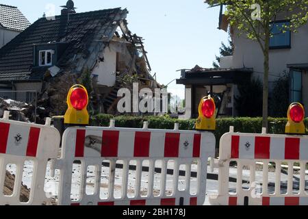 Colonia, Germania. 23 aprile 2020. Pezzi di macerie giacciono davanti alle case danneggiate. Dopo l'esplosione di una casa e la successiva scoperta di un cadavere a Colonia, l'indagine continua. La casa di schiera nel distretto di Buchheim era stata completamente distrutta dall'esplosione. Credit: Federico Gambarini/dpa/Alamy Live News Foto Stock