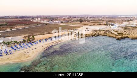 Vista aerea del tramonto sulla costa e della spiaggia simbolo di Agia Thekla, Ayia Napa, Famagosta, Cipro dall'alto. Vista dello skyline dall'alto dell'attrazione turistica Foto Stock