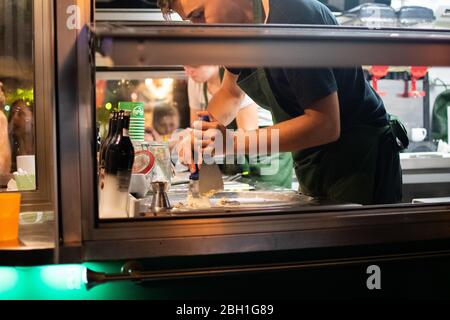 Uomo che prepara il gelato durante il festival fast food Foto Stock