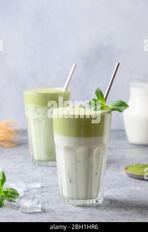 Due bicchieri di tè Dalgona Matcha latte con tè montato. Primo piano. Formato verticale. Foto Stock