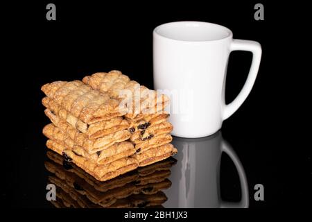 Molto biscotto di puff quadrato intero con uvetta con caffè isolato su vetro nero Foto Stock