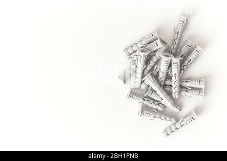 Tasselli in plastica isolati su sfondo bianco. Spina a parete, tassello a vite, utensili da costruzione. Foto Stock
