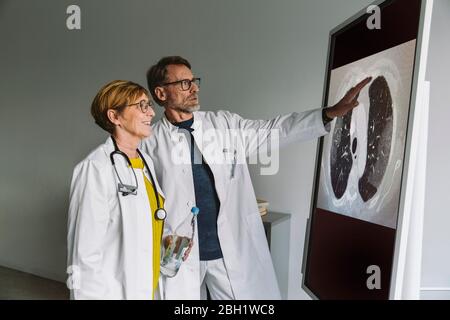 Due medici discutono presso la smart board Foto Stock