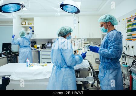 Medici che preparano la stanza di trauma di un ospedale Foto Stock