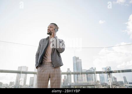 Uomo elegante al telefono sulla terrazza di osservazione con vista sullo skycraper, Francoforte, Germania Foto Stock