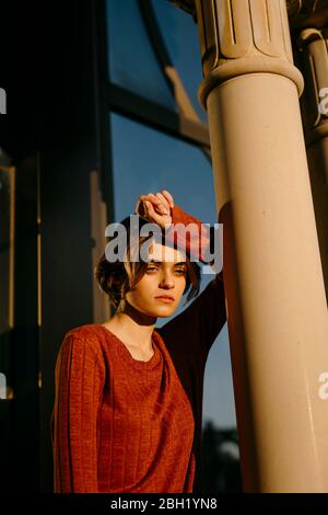 Ritratto di giovane triste donna che pende su una colonna Foto Stock