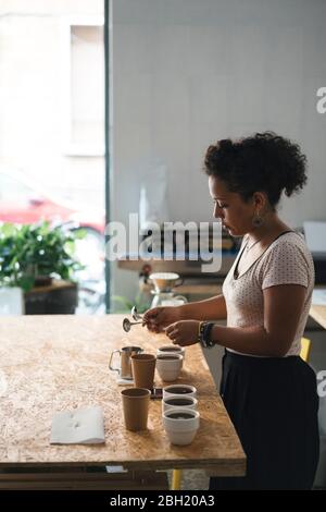 Donna che lavora in una torrefazione del caffè che prepara il caffè Foto Stock