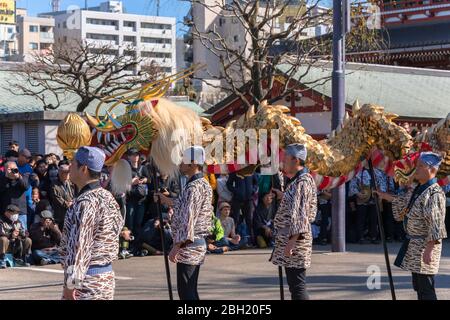 tokyo, giappone - marzo 18 2020: Maestri giapponesi di marionette che tengono un enorme drago d'oro per il tradizionale festival di danza dedicato al bodhisattva Kan Foto Stock