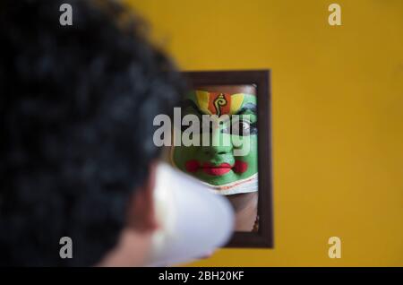 Ballerina di Kathakali che guarda nello specchio e sorridente. Foto Stock