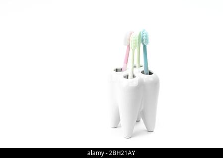 supporto per spazzolino a forma di dente primario con spazzolini colorati Foto Stock