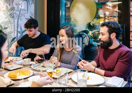 Amici che cenano in un ristorante elegante Foto Stock