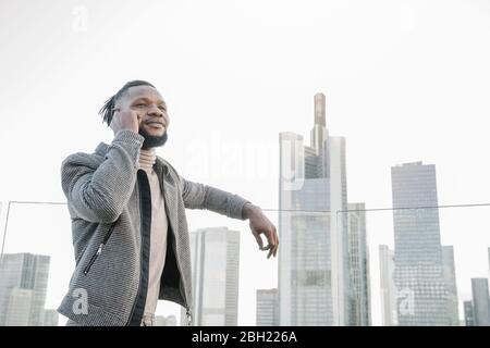 Uomo elegante al telefono sulla terrazza di osservazione con vista sullo skycraper, Francoforte, Germania Foto Stock