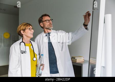 Due medici discutono presso la smart board Foto Stock