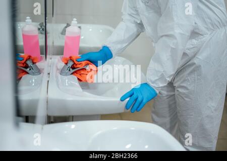 Pulizia personale desinfezione ospedale contro virus scandaloso, indossare indumenti protettivi, primo piano Foto Stock