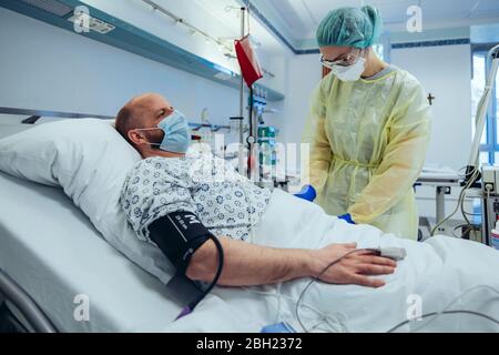 Medico curante per il paziente in pronto soccorso di un ospedale che preleva il campione di sangue Foto Stock