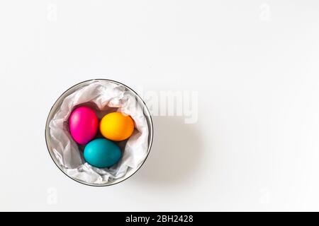 Tre uova di Pasqua tinte in una ciotola su un terreno di bachground bianco Foto Stock