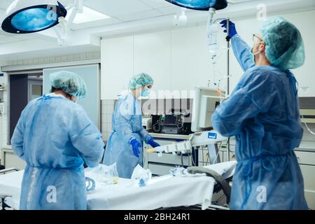 Medico preparante flebo IV in sala trauma di un ospedale Foto Stock