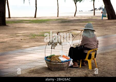 SONGKLA, THAILANDIA - AGOSTO 17 : Old thai donna gente venditore portare cesto di falco seduto vendita cibo e snack per i viaggiatori sul sentiero stradale di Sam Foto Stock