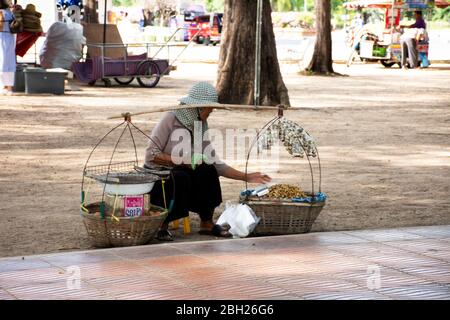 SONGKLA, THAILANDIA - AGOSTO 17 : Old thai donna gente venditore portare cesto di falco seduto vendita cibo e snack per i viaggiatori sul sentiero stradale di Sam Foto Stock