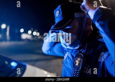 Ritratto di poliziotto che indossa maschera e guanti protettivi di notte Foto Stock