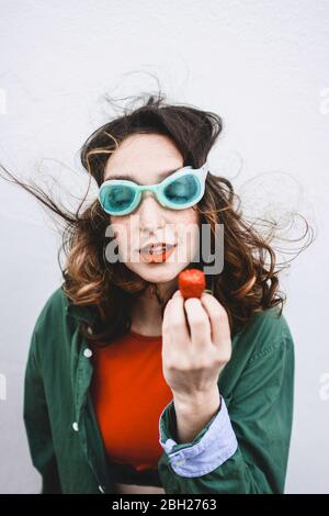 Ritratto di donna che indossa occhiali da immersione mangiare fragola Foto Stock