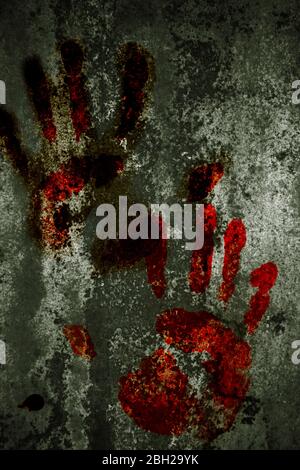 Primo piano di sanguinose stampe a mano su pareti grigie Foto Stock