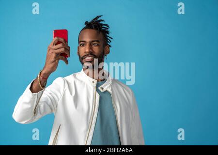 Ritratto di giovane uomo alla moda che prende un selfie Foto Stock