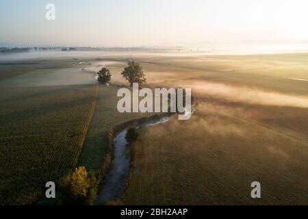 Germania, Baviera, Drone vista del fiume Aisch e paesaggio circostante campagna all'alba nebbia Foto Stock