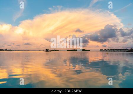 Bel tramonto con nuvole e riflessi sull'acqua, maschio, Maldive Foto Stock