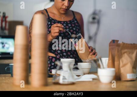 Donna che lavora in una torrefazione del caffè che prepara il caffè Foto Stock
