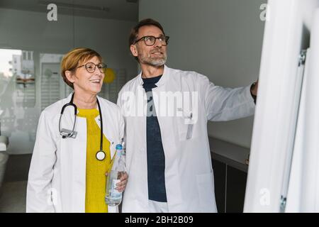 Due medici discutono presso la smart board Foto Stock