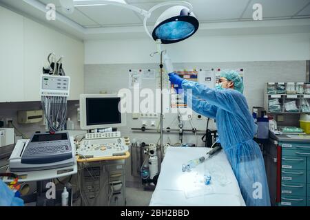 Medico preparante flebo IV in sala trauma di un ospedale Foto Stock