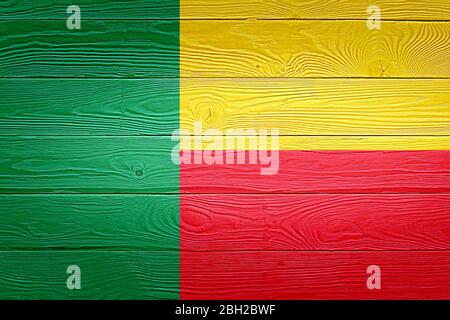 Bandiera Benin dipinta su vecchio sfondo legno plancia. Superficie dell'asse in legno annodato con luce naturale spazzolata. Bandiera di sfondo texture di legno del Benin. Foto Stock