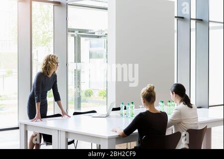 Donne d'affari che hanno una riunione in un ufficio luminoso Foto Stock