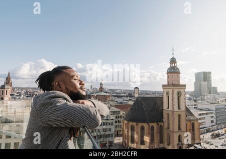 Uomo elegante sulla terrazza di osservazione, Francoforte, Germania Foto Stock