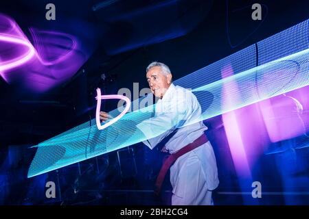 Composto di uomo anziano che pratica il karate Foto Stock