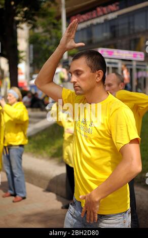 Seguaci del movimento religioso Falun dafa che fa ginnastica respiratoria Chi Kung in strada Foto Stock